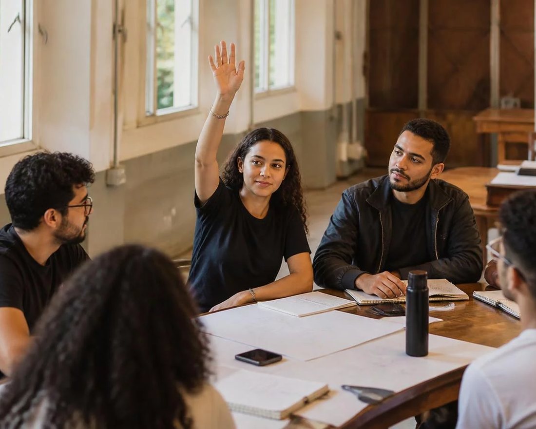 Roda de participantes; um deles repete em voz alta o argumento do colega antes de apresentar a réplica